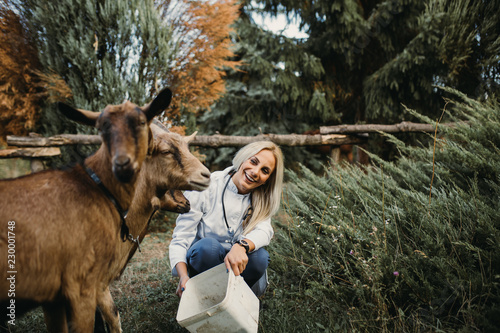 Fototapeta Naklejka Na Ścianę i Meble -  Veterinarian and beautiful goat outdoors at ranch.
