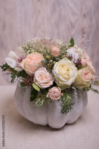 floral bouquet in a white pumpkin on a light background, a mixture of flowers, peony rose, eucalyptus, chrysanthemum, Brassica, white orchid, cotton