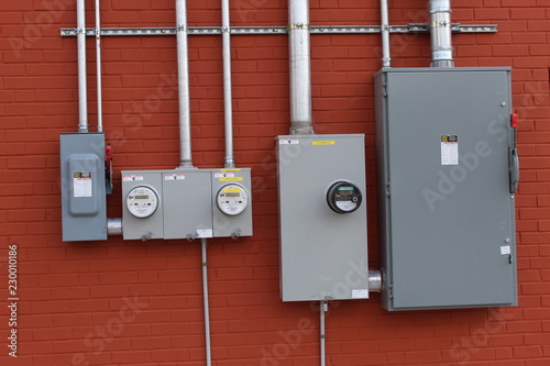Electrical boxes along brick wall