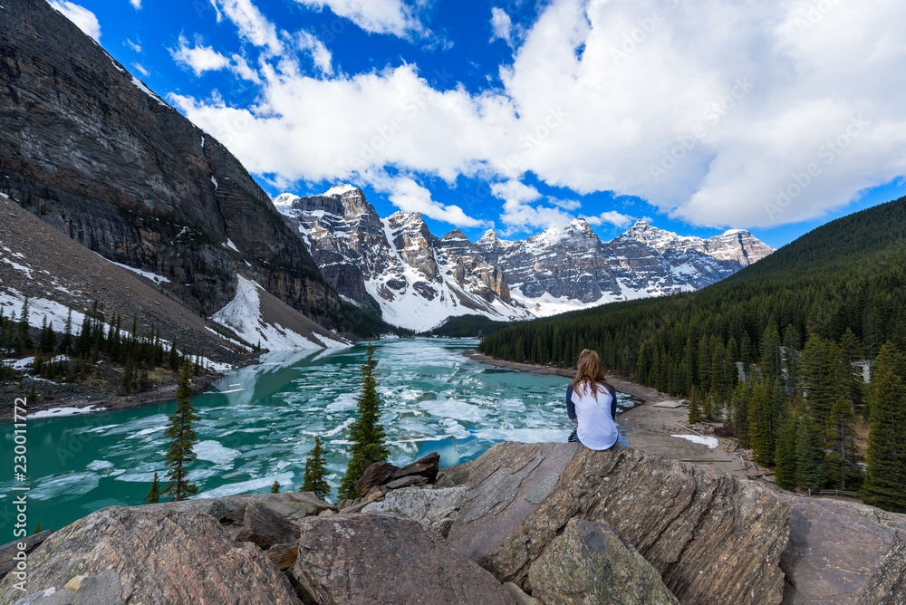 A young girl enjoys Moraine Lake view in early summer, Banff National Park, Canada