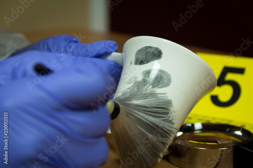 Forensic expert finds fingerprints on the cup of coffee. Crime scene