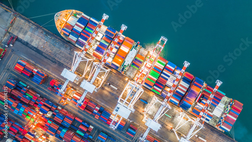 Aerial top view crane shipping container at night  cargo container ship carrying container import and export business logistic and transportation.
