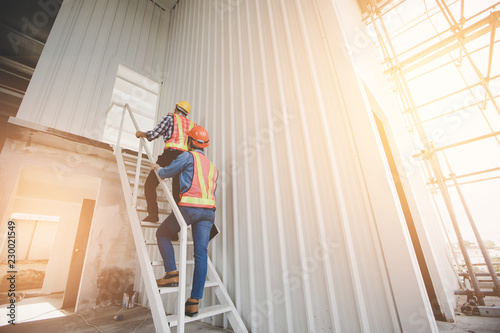 Two engineers were walking up the stairs to survey the construction site, Engineering Safety Concept.