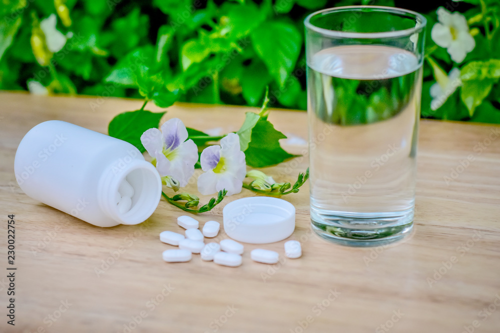 Paracetamol for reducing fever is placed on the table and a glass of water is available,Paracetamol with water Paracetamol for reducing fever is placed on the table and a glass of water is available,Paracetamol with water