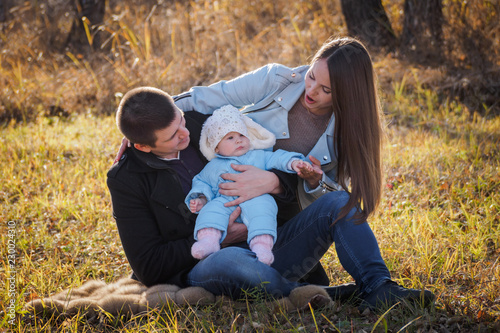 Canvastavla husband and wife sitting in the Park on the grass holding a baby on your lap who