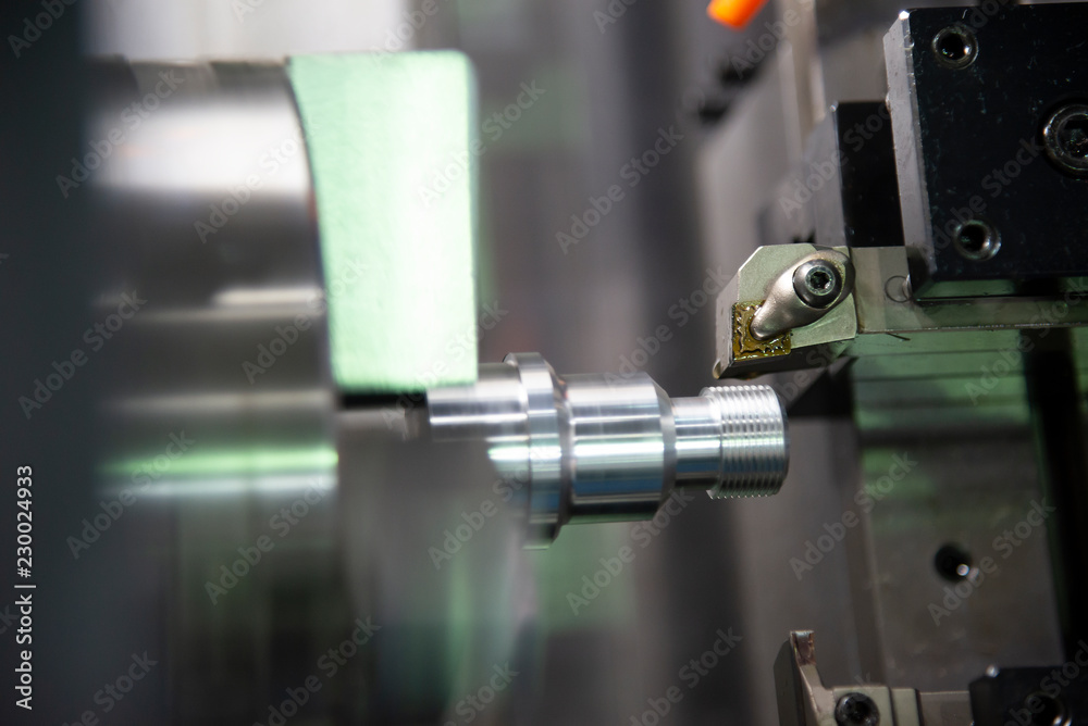The CNC lathe or turning machine cutting  the thread  at the metal shaft.Hi-technology manufacturing process.