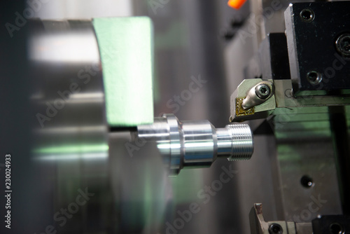 The CNC lathe or turning machine cutting the thread at the metal shaft.Hi-technology manufacturing process.