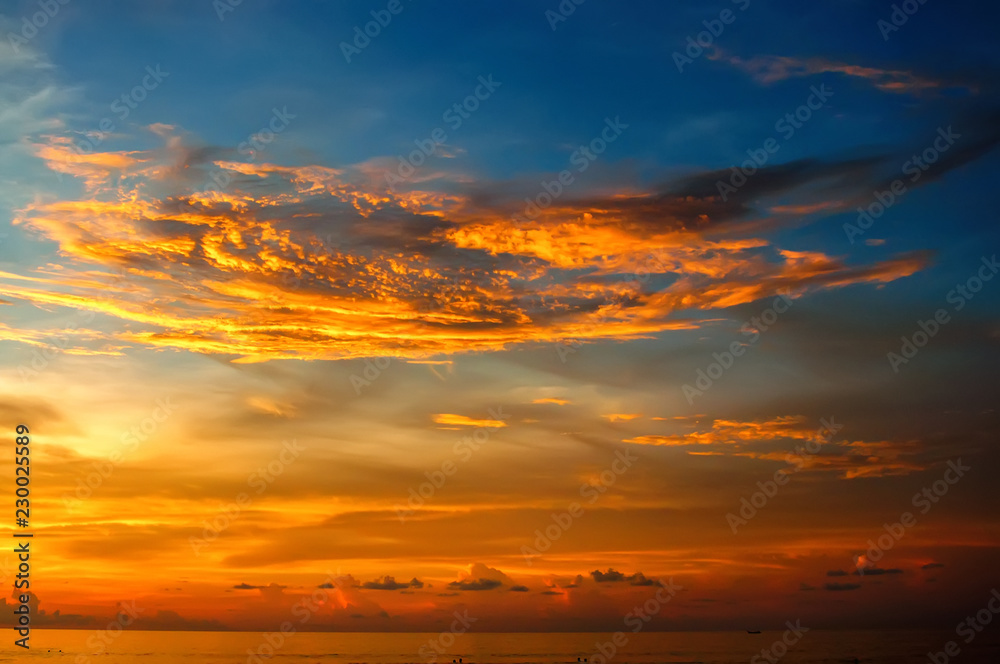 Fototapeta premium Beautiful scenery of the ocean at sunset with a wave on the shore and bizarre clouds