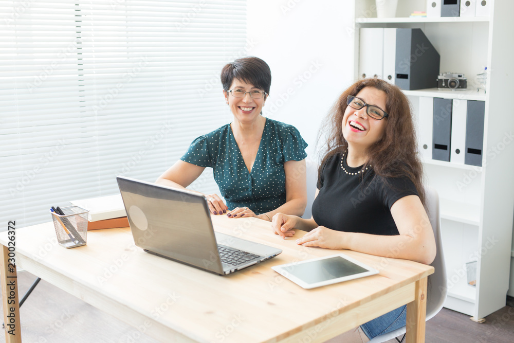 Two happy businesswoman working together in office Two happy businesswoman working together in office