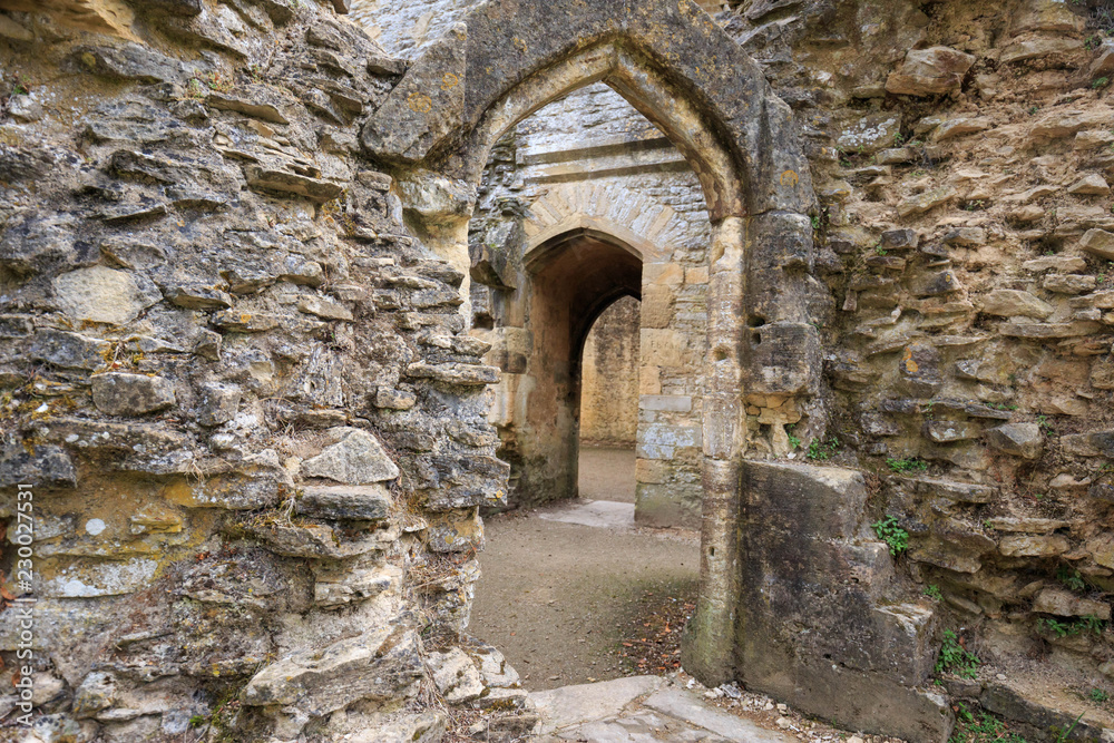 Open arched door through ancient brick wall in ruins of English church