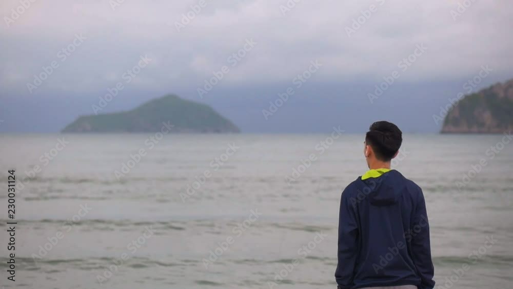 Handsome man running standing on the beach looking out at sea view, Sportsman stretching before running along the beach. Handsome man running standing on the beach looking out at sea view, Sportsman stretching before running along the beach.