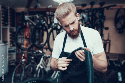 Young Mechanic Repairs Bicycle Tube in Workshop photo