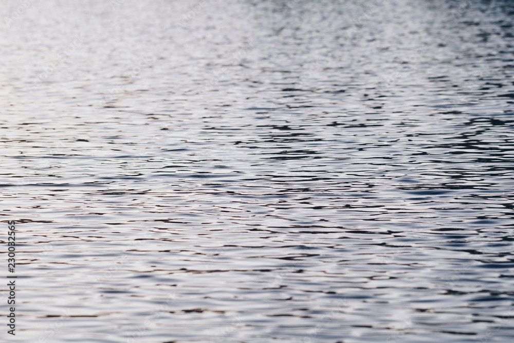 Calm water river background with reflection at sunset.