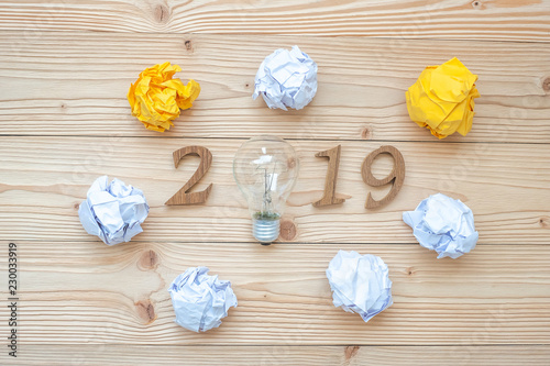 2019 Happy New years with lightbulb with crumbled paper and wooden number on table. New Start, Idea, Creative, Innovation, Resolution, Solution, Strategy, Goals and Mission concept