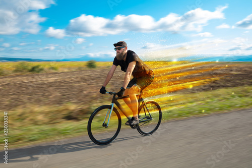 Young riding bicycle in fabulous nature with high speed