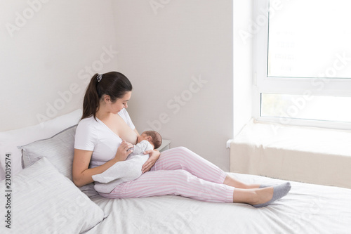 Young mother breastfeeding her newborn baby son. Happy mom hugging her babyboy close-up. Breast feeding and lactation infant concept.