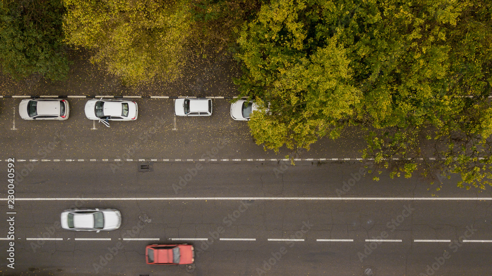 Aerial Drone Flight top down view of freeway busy city rush hour heavy traffic jam highway. Aerial view of the vehicular intersection, traffic at peak hour with cars on the road, fly under trees. Aerial Drone Flight top down view of freeway busy city rush hour heavy traffic jam highway. Aerial view of the vehicular intersection, traffic at peak hour with cars on the road, fly under trees.