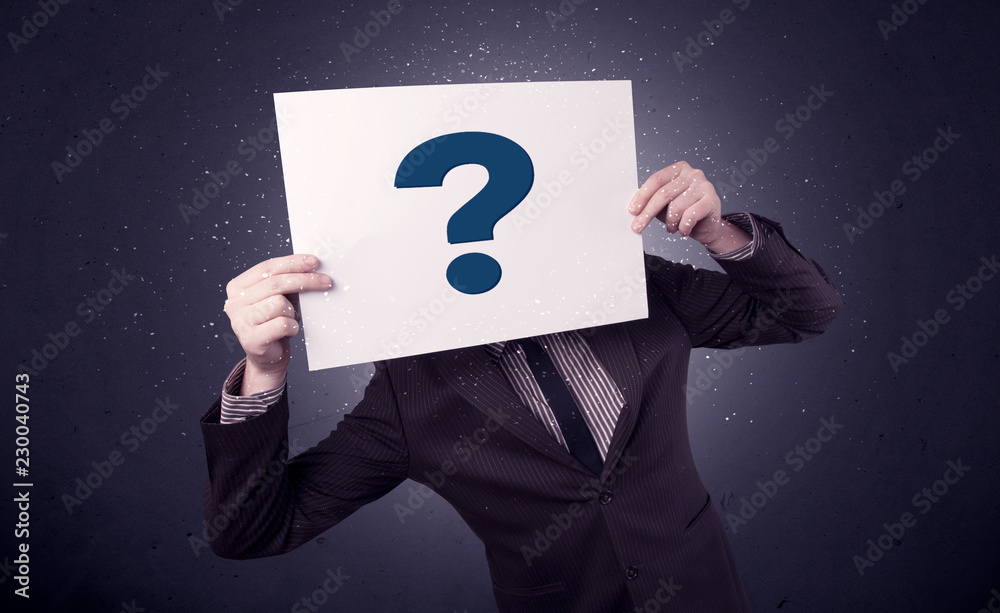 Young businessman hiding behind a question mark drawn on paper Young businessman hiding behind a question mark drawn on paper