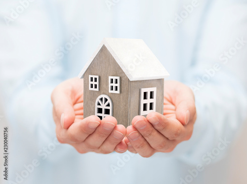 Small wooden toy house in hands 