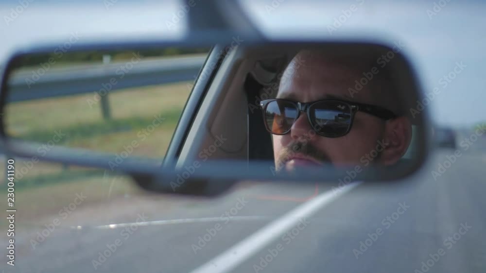 Young man driving a car. Man sitting and driving in the car. Trip of a in sunny weather. Young man driving a car. Man sitting and driving in the car. Trip of a in sunny weather.