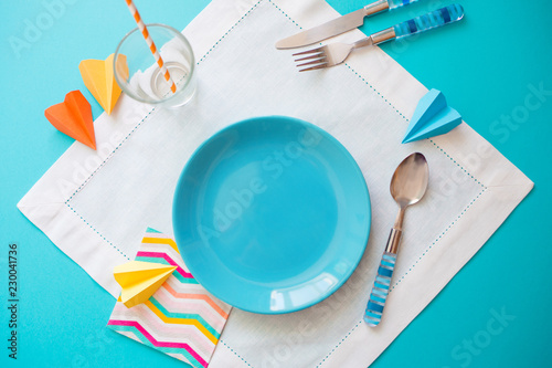 empty plate and Cutlery on white blue background. concept of kids menu of a cafe or restaurant
