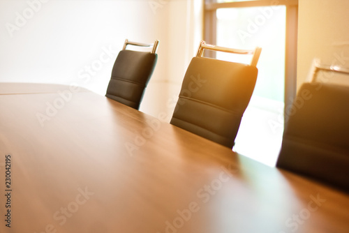 Wooden table in meeting room and sunlight in back side.