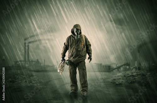 Gas masked survival man coming with arms on his hand  in a demolished dark environment    © ra2 studio