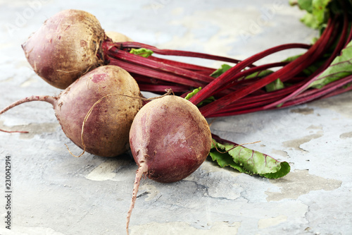 Red Beetroot with herbage green leaves on rustic background. Organic Beetroot