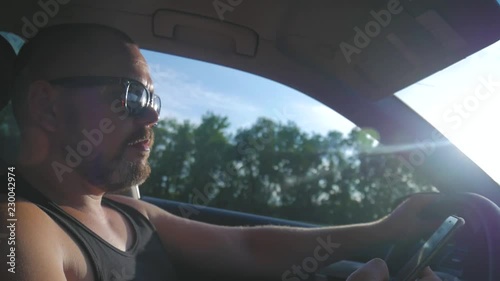 Wallpaper Mural Young man driving a car. Man sitting and driving in the car. Trip of a in sunny weather. Torontodigital.ca
