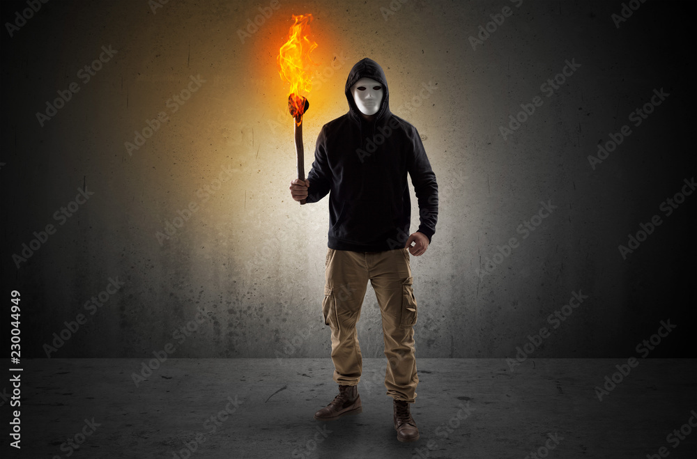 Ugly scary man with burning flambeau walking in an empty space Stock Photo