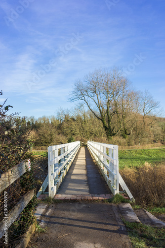 The footbridge over the Cuckmere river at Alfriston, UK on the South Downs Way a national trail from Eastbourne to Winchester, on a sunny winters day.
