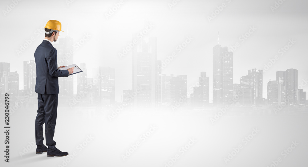 Young supervisor architect standing and looking at a big city panorama
Young supervisor architect standing and looking at a big city panorama