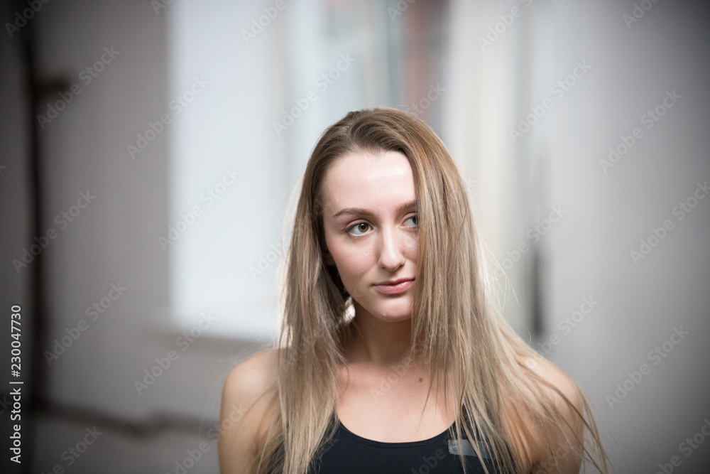 Young attractive woman in sport bra in training studio. Looking to the side Young attractive woman in sport bra in training studio. Looking to the side