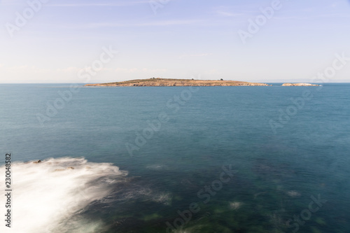 The island in the Black Sea. A view of the stony island in the high sea. View from cafe. City of Sozopol. Bulgaria