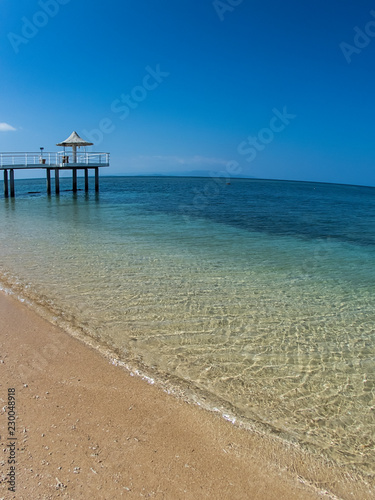 A Long Pier over a Tropical Blue Clear Sandy Beach with No Clouds on Clear Day in Ishigaki  Okinawa Japan