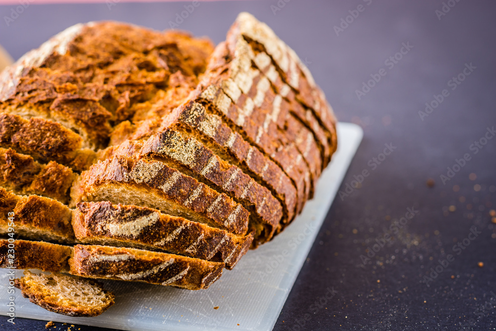 Sliced bread over a white surface and dark background. Sliced bread over a white surface and dark background.