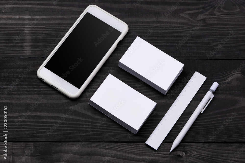 Mockup of cellphone with blank screen and business cards Mockup of cellphone with blank screen and business cards