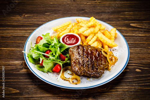 Grilled steak, French fries and vegetables