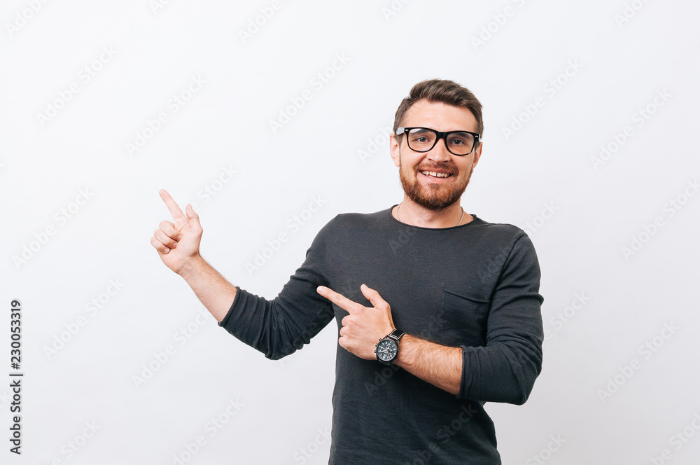 Young happy man with beard pointing away over white background Young happy man with beard pointing away over white background