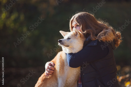 Young woman on a walk with her dog breed Akita inu