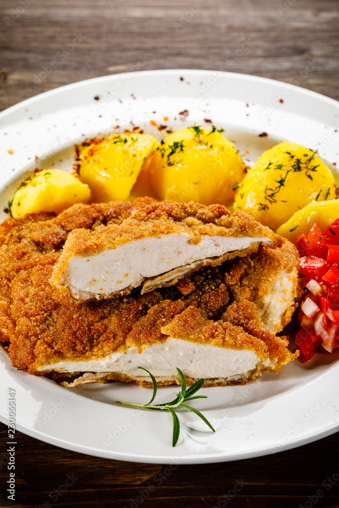 Fried pork chop, boiled potatoes and vegetable salad Fried pork chop, boiled potatoes and vegetable salad
