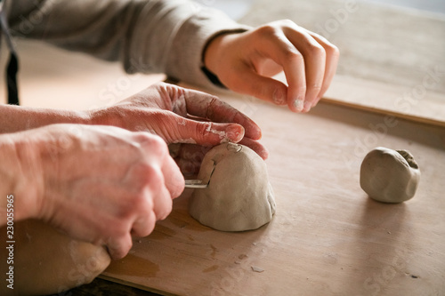 Little boy sculpts from clay with interest