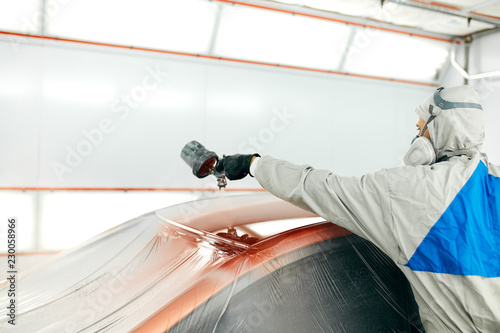 repairman painter in chamber painting automobile car roof photo