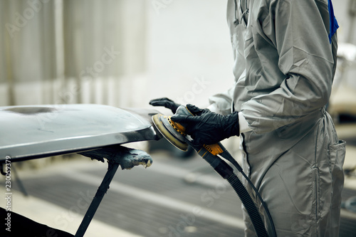 фотографія mechanic worker repairman sanding polishing car and preparing automobile for pai