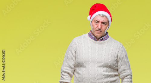 Handsome senior man wearing christmas hat over isolated background depressed and worry for distress, crying angry and afraid. Sad expression.