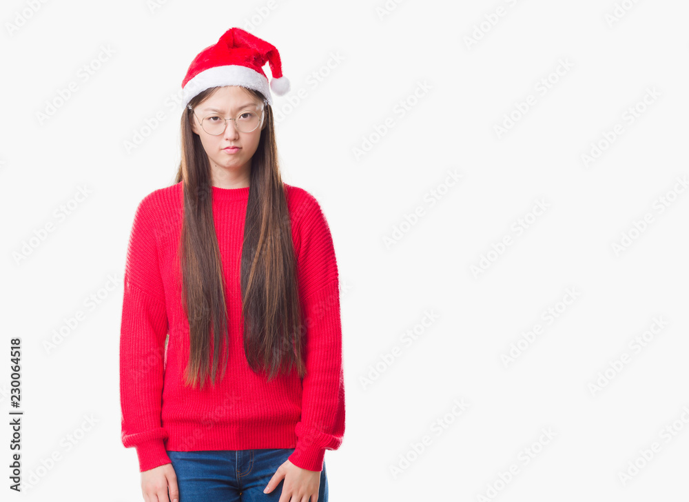 Young Chinese woman over isolated background wearing christmas hat skeptic and nervous, frowning upset because of problem. Negative person. Young Chinese woman over isolated background wearing christmas hat skeptic and nervous, frowning upset because of problem. Negative person.