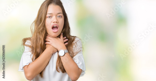 Young beautiful brunette business woman over isolated background shouting and suffocate because painful strangle. Health problem. Asphyxiate and suicide concept.