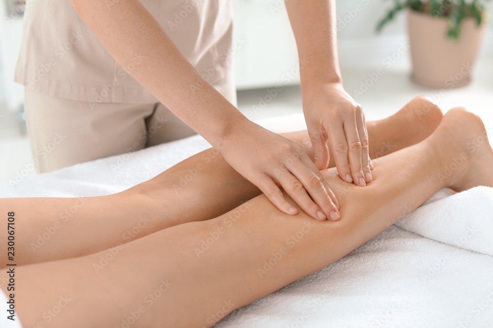 Woman receiving leg massage in wellness center, closeup