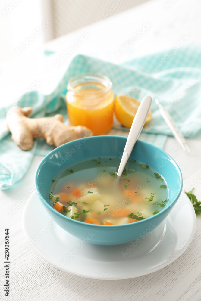 Bowl of fresh homemade soup to cure flu on wooden table