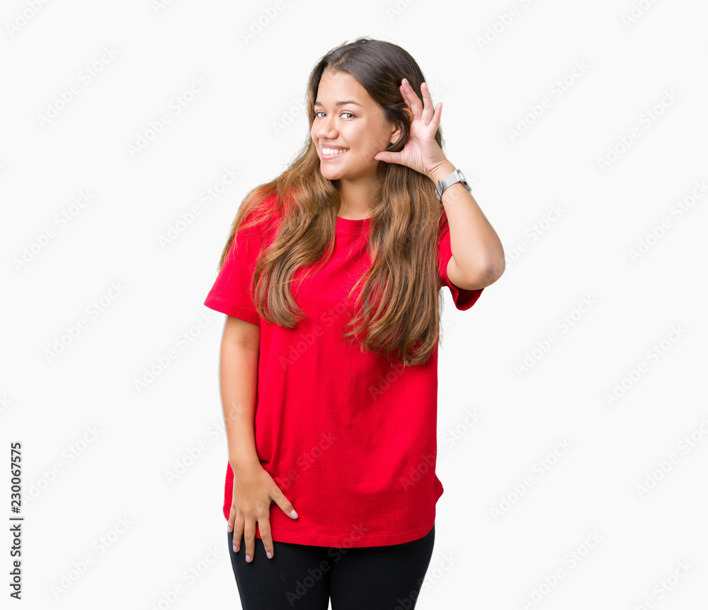 Young beautiful brunette woman wearing red t-shirt over isolated background smiling with hand over ear listening an hearing to rumor or gossip. Deafness concept. Young beautiful brunette woman wearing red t-shirt over isolated background smiling with hand over ear listening an hearing to rumor or gossip. Deafness concept.